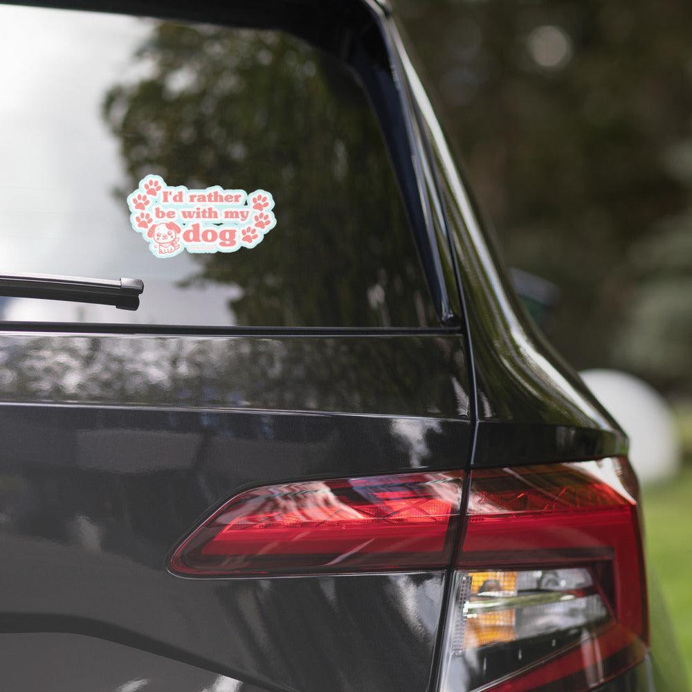 Car window with a decal reading 'I'd rather be with my dog' on a blurred natural background