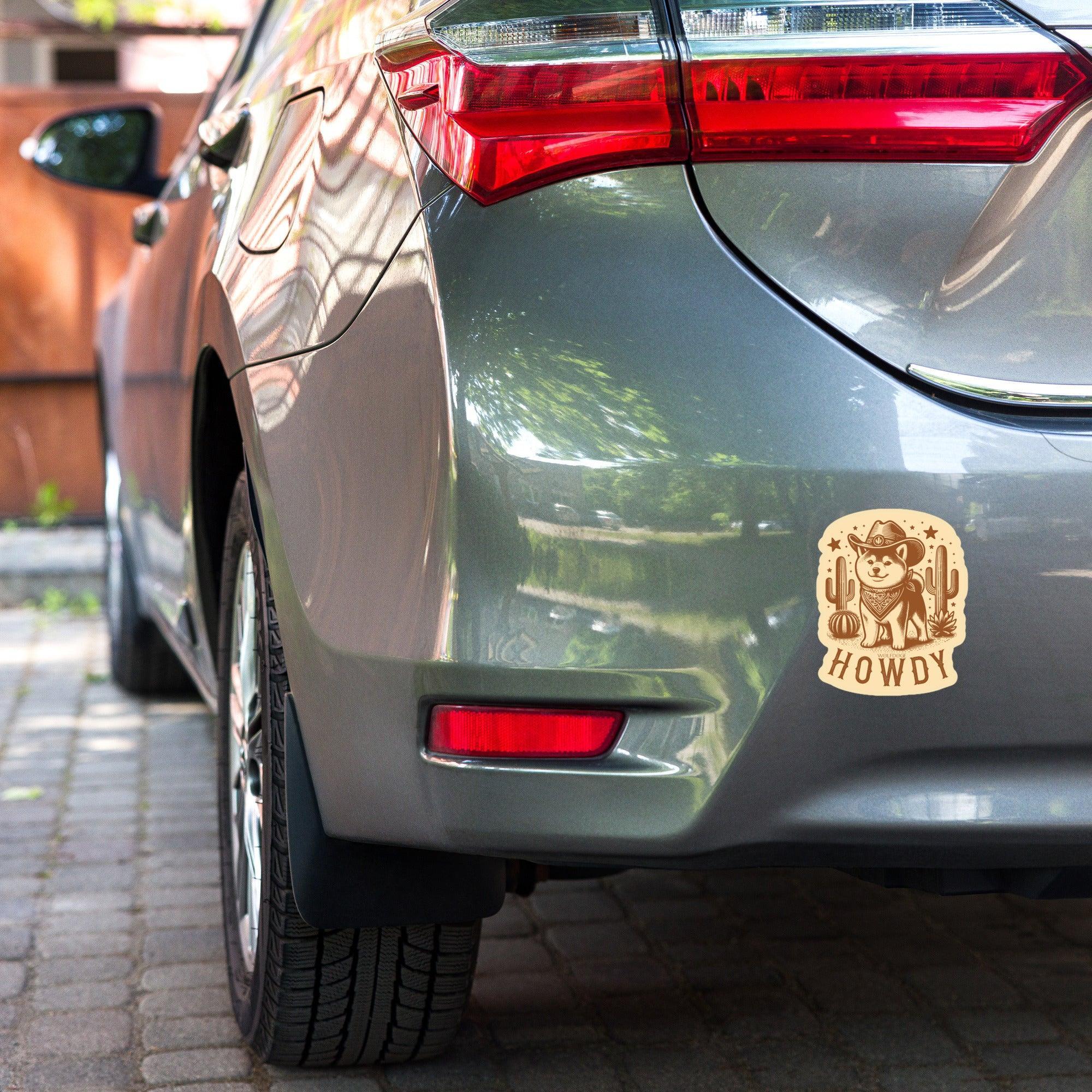 Car with a 'Howdy' sticker on the back, parked outdoors.